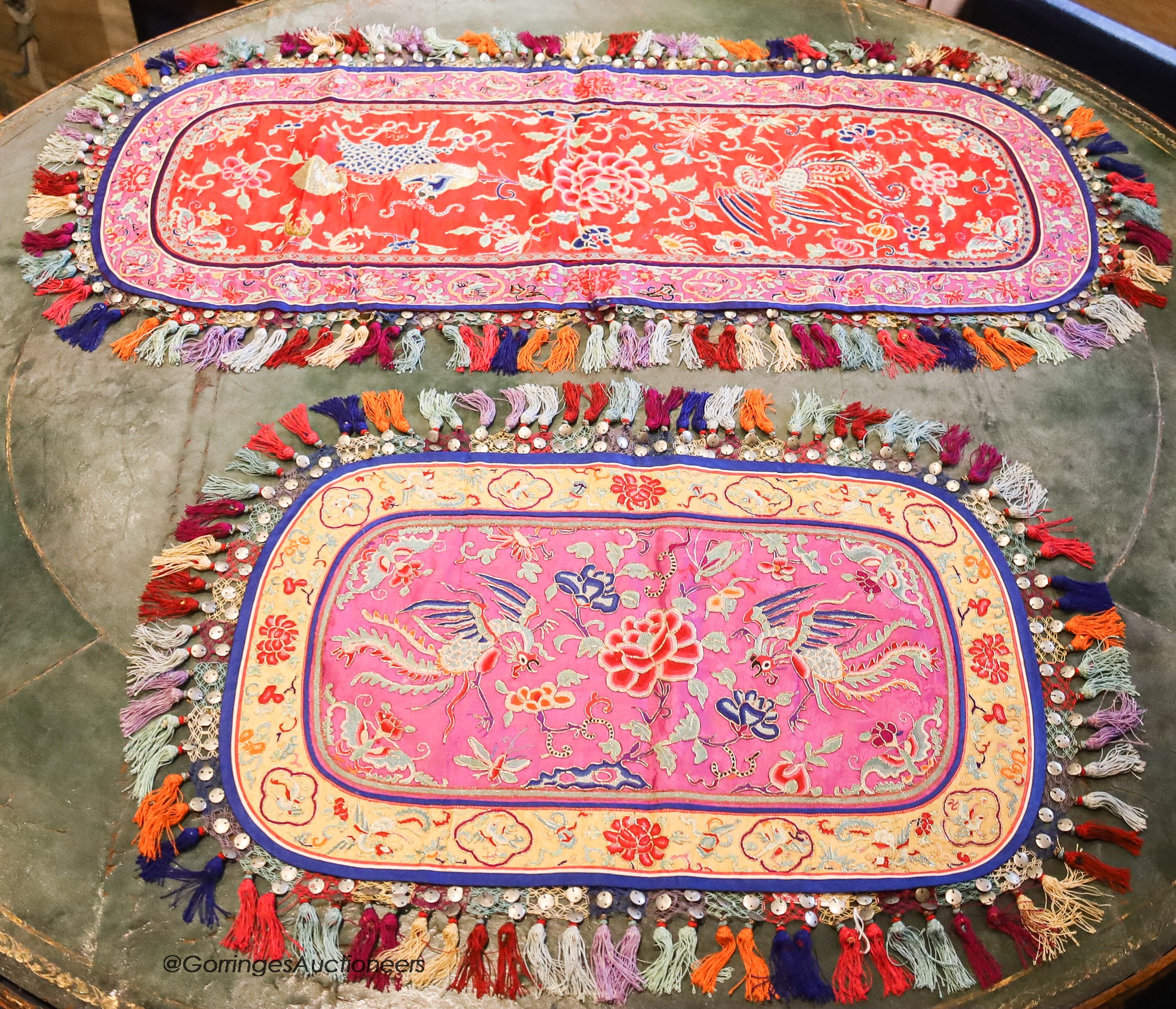 Four 20th century silk embroidered oval table centres edged with multi-coloured tassels, length 96cm